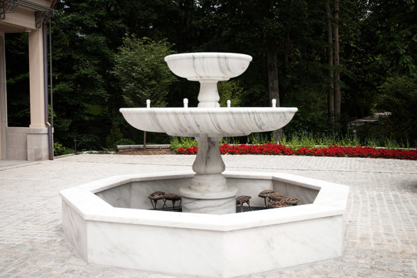Elegant Stone Water Fountain At The Trone Residence, Showcasing Intricate Carvings And Expert Craftsmanship.